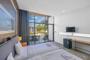 a bedroom with a bed and a large window at Sunset Serenity Jomtien Resort in Na Jomtien