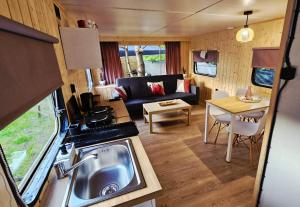 eine Küche und ein Wohnzimmer mit Sofa und Tisch in der Unterkunft Domeczek in Sulęczyno