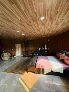 a bedroom with a large bed with a wooden ceiling at Neverland Resort مزرعة نيفرلاند in Irbid