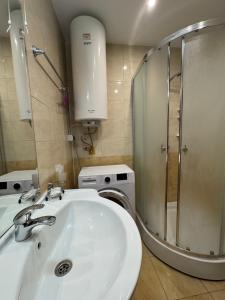 a bathroom with a sink and a washing machine at VP Palazzo Nesebar in Nesebar +27 photos