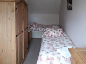 une petite chambre avec deux lits et une armoire dans l'établissement Swiss Cottage - E5375, à Alrewas