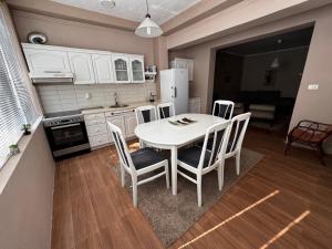 una cucina con un tavolo bianco e sedie in una stanza di Apartment 59 a Gevgelija Altre 2 foto