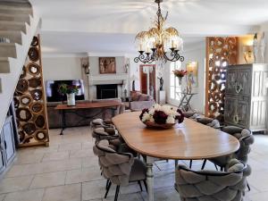 a living room with a wooden table and chairs at Mas De La Coste in Fayence