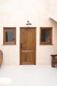 a wooden door on a white wall with two windows at Casa Bel - Apartment 6 in Miami Platja