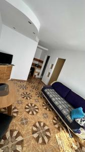 a living room with a blue couch on the floor at na rogu in Pobierowo