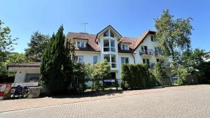 a large white house with a fence and trees at na rogu in Pobierowo
