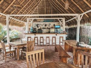 a bar in a resort with wooden tables and chairs at Monoloko Lodge Popoyo in Popoyo
