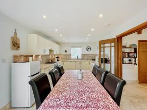 a kitchen with a table with black chairs around it at Copper Cottage in Atworth