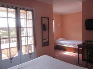 Un pat sau paturi într-o cameră la Hotel La Chaumière