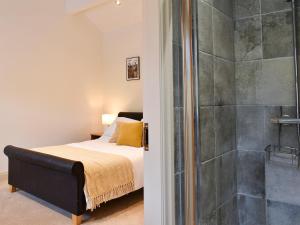 a bedroom with a bed and a shower at Swaledale Cottage - Barley Green Mill in Barrowford +9 photos
