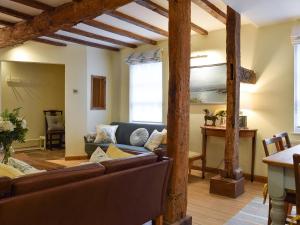 a living room with couches and a table at The Lovely Old Cottage in Stratford-upon-Avon