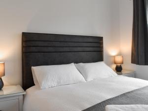 Un dormitorio con una cama grande con dos lámparas. en Hillside At Bowness, en Windermere 12 fotos más