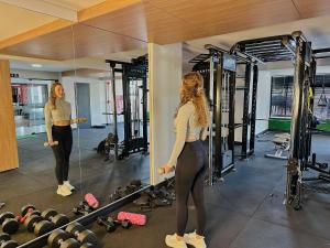 a woman standing in front of a mirror in a gym at ApartDamani - short rental apartments in Foz do Iguaçu +181 photos