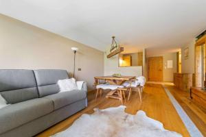 a living room with a couch and a table at Chic Wellness Apartment and Balcony in Maloja