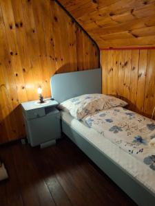 a bedroom with a bed and a nightstand with a lamp at Waldpoesie - Das Wald-Cottage in Benking