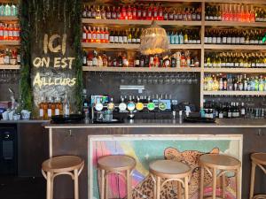 a bar with stools and bottles of alcohol at Le Studio Romie in Le Portel