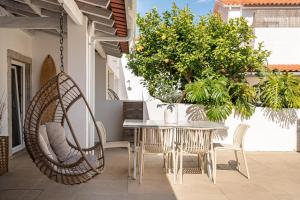 a patio with a table and chairs and a swing at Sea'Ya Thoughtful Stays - Villas in Cascais