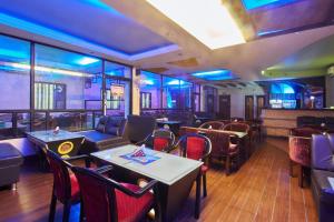 a restaurant with tables and chairs in a room at Golden Sun Inn Hotel in Pondicherry