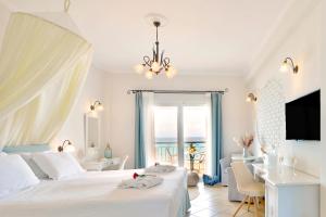 a bedroom with a bed and a desk and a window at Delfino Blu Wellness Boutique Hotel in Agios Stefanos +132 photos