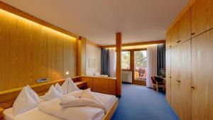 - une chambre avec un lit et des oreillers blancs dans l'établissement Hotel Tirol, à Tirolo