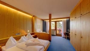 ティローロにあるHotel Tirolのベッドルーム(白い枕のベッド1台付)