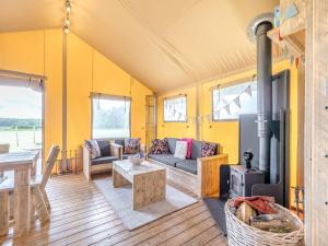 Una sala de estar con un sofá y una estufa de leña. en Muntjac - Uk47396, en Bawdeswell