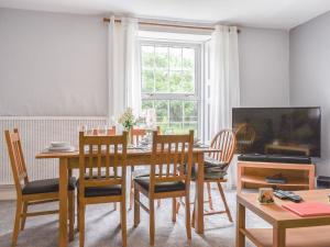 a dining room with a table and chairs and a television at Laurel Farm in Rolstone +18 photos