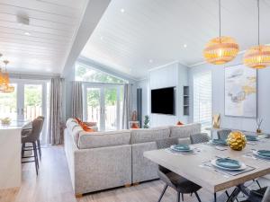 a living room with a couch and a table at Three Sandbanks in Benllech