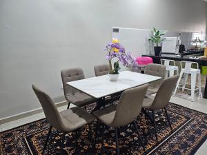 Un comedor con una mesa y sillas blancas. en Nur's Homestay 2, en Kuantan 7 fotos más
