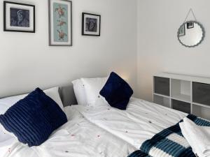 a white bed with blue pillows in a bedroom at Rutland Retreat in Filey
