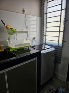 una pequeña cocina con fregadero y encimera en Nur's Homestay 2, en Kuantan