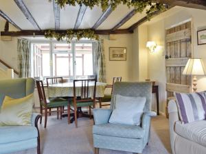 a living room with chairs and a table at Rose Cottage in Chipping Campden