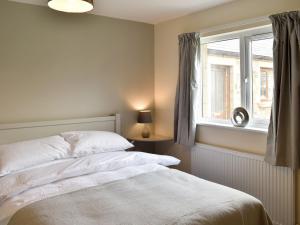 a bedroom with a white bed and a window at Five Dorchester Drive - Uk32043 in Inglewhite