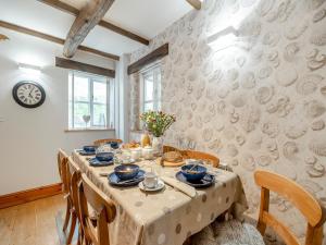 ein Esszimmer mit Tisch und Stühlen und einer Uhr in der Unterkunft Nobles Cottage - Uk43351 in Whitby + 14 Fotos