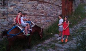 a group of children riding on a donkey with a woman at Кюповата къща 1860 Qpova house in Kovačevica +33 photos