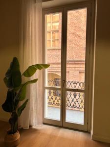 an open door with a window and a plant at Casa Crova in Nizza Monferrato