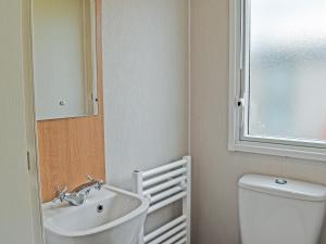 a bathroom with a sink and a toilet and a mirror at Ocean Edge in Heysham