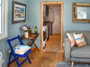 a living room with a chair and a table at Seaglass Chalet - Uk47636 in Mundesley