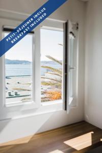 a window with a view of the beach at Hôtel Les Voiles in Toulon