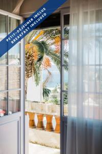 a door to a building with a palm tree outside at Hôtel Les Voiles in Toulon