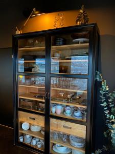 a glass cabinet with dishes in it at House of Ellie 2 in Tromsø +30 photos