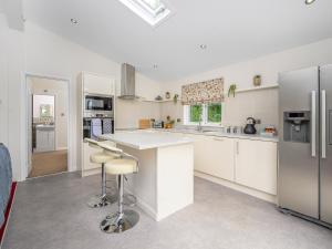 a kitchen with white cabinets and stainless steel appliances at Butterfly Lodge in East Farndon