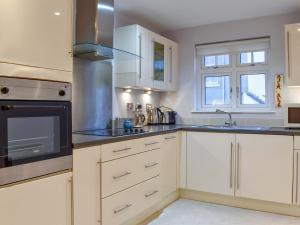 a kitchen with white cabinets and a sink at The Retreat in Whitby