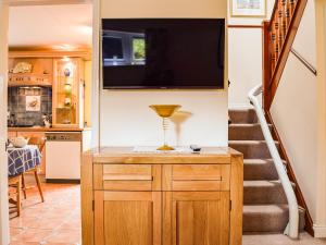 a kitchen with a staircase and a television on the wall at The Old Exchange in Market Bosworth