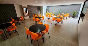 a restaurant with orange chairs and tables in a room at Hotel Avanty in Ipiales