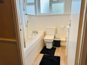 a bathroom with a toilet and a tub and a sink at Luxe 2 Bedroom House Derby City in Derby +47 photos