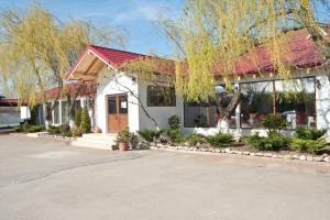 a white house with a red roof at Pension Club Montana in Campina