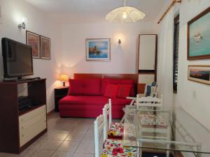 a living room with a red couch and a tv at Apartman Karla in Makarska