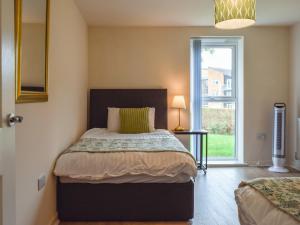 a bedroom with a bed and a large window at Frank Wright Apartment in Sheffield