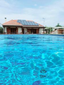 a house with solar panels on top of a swimming pool at Johnny Jo Villa in Aígio